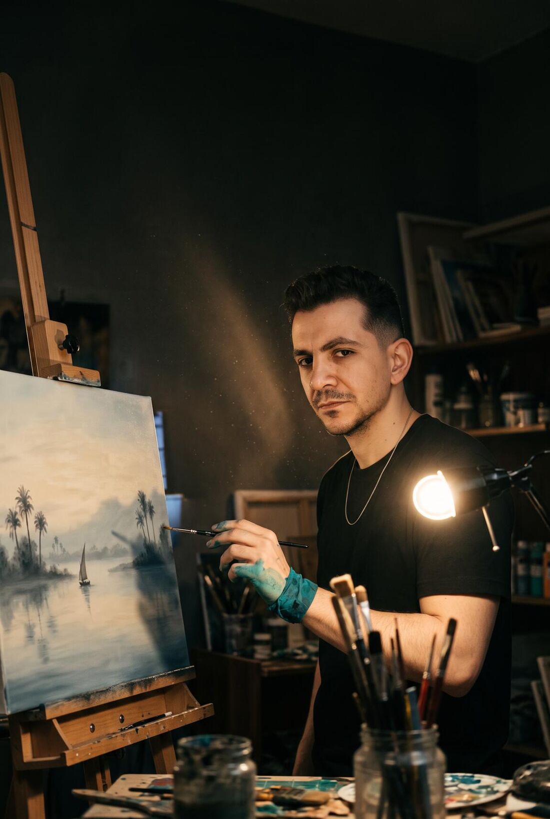 إيهاب يوسف في مرسمه قدّام لوحة للنيل